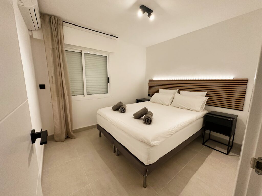 Slaapkamer met boxspring en houten hoofdbord